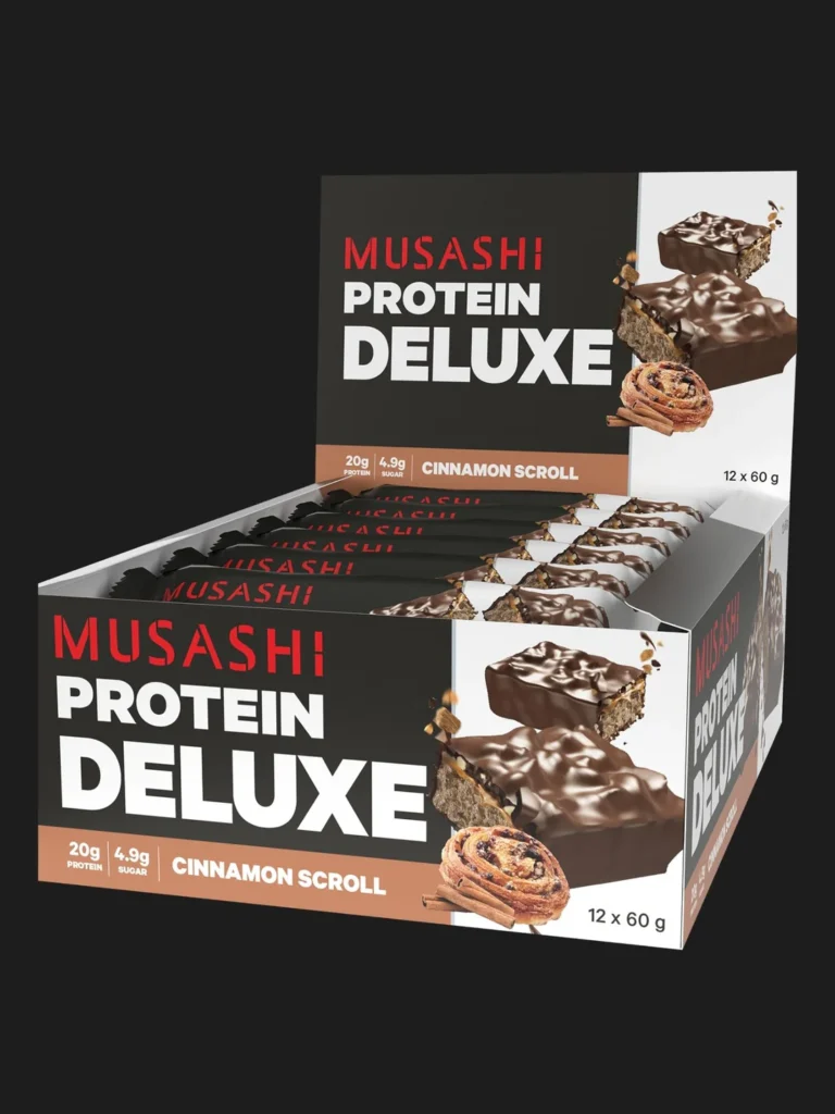 Musashi Protein Deluxe bars in Cinnamon Scroll flavor, displayed in a 12-bar box with chocolate-coated bars and cinnamon scroll imagery.