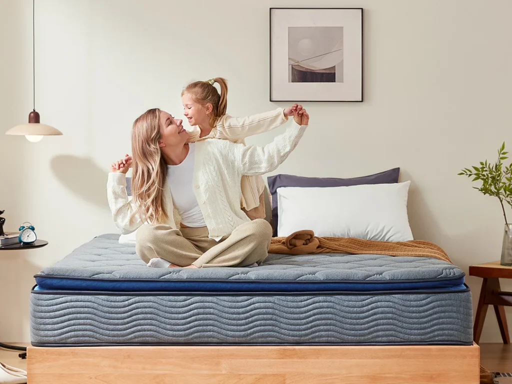 Mother and daughter sitting on a Newentor hybrid mattress, enjoying comfort and support in a cosy, modern bedroom. Discover premium sleep products at www.waiteandsea.com.au.