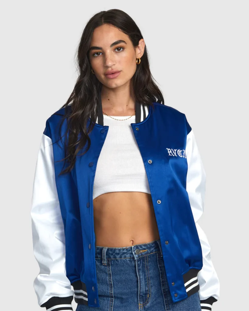 Front view of a woman wearing a blue and white varsity jacket with "RVCA" embroidery on the chest.