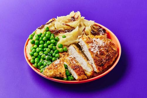 A comforting plate of cheesy chicken schnitzels, creamy mashed potatoes with caramelised onions, and vibrant green peas.