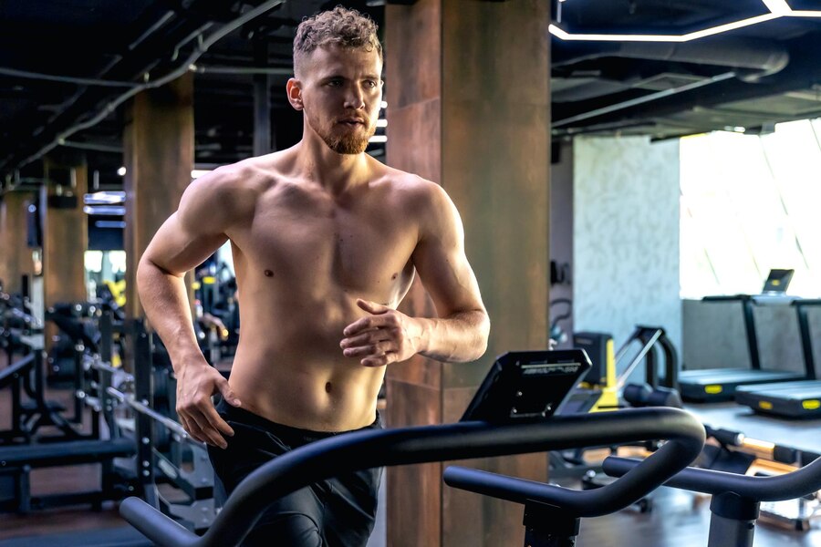 Athletic man running on a treadmill in a modern gym, showcasing focus and determination in achieving health and fitness goals. Learn more at www.waiteandsea.com.au.