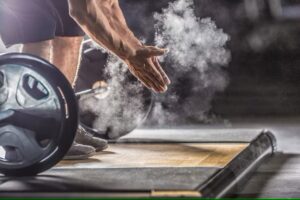 Athlete preparing for a heavy lift with chalked hands in a gym. Strength training and weightlifting for health and fitness. www.waiteandsea.com.au