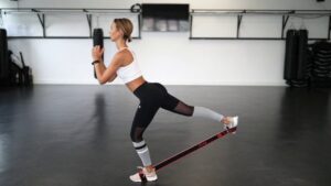 Woman performing resistance band glute exercise in gym, promoting health and fitness – www.waiteandsea.com.au